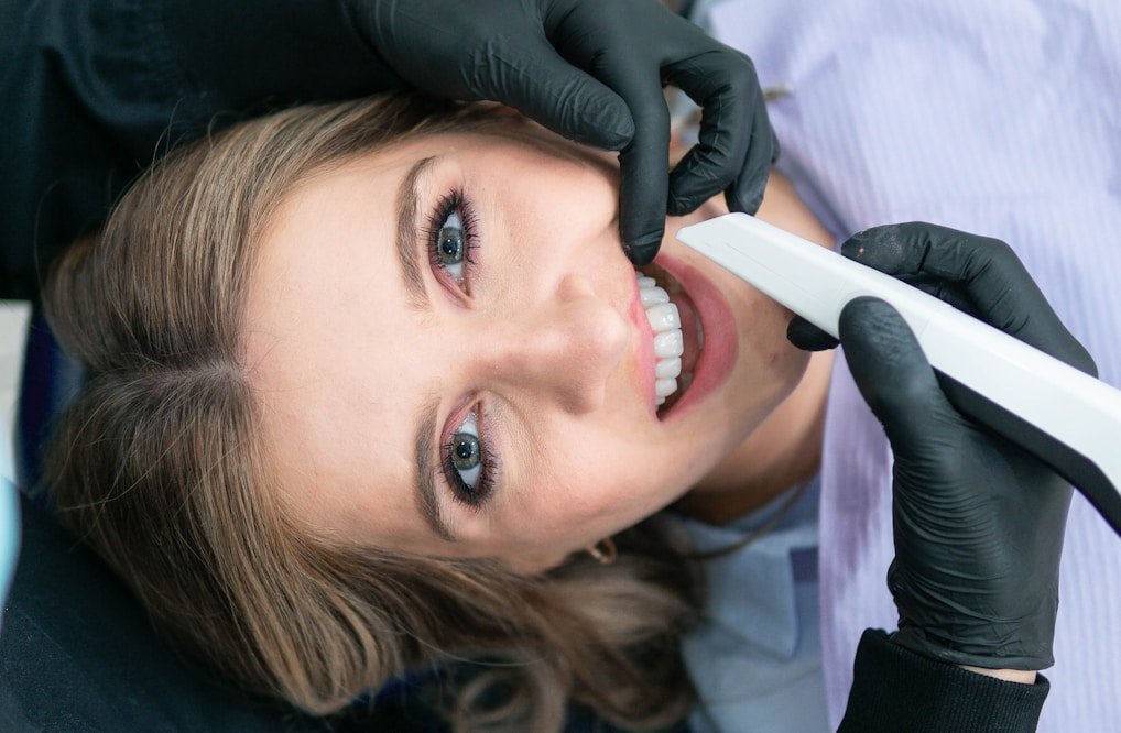 a woman is smiling while holding a toothbrush
